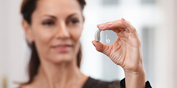woman_holding_oticon_real_hearing_aid