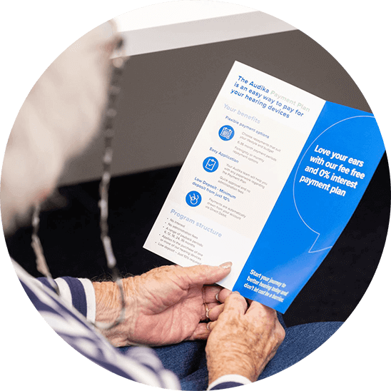 woman holding hearing aids payment plan brochure