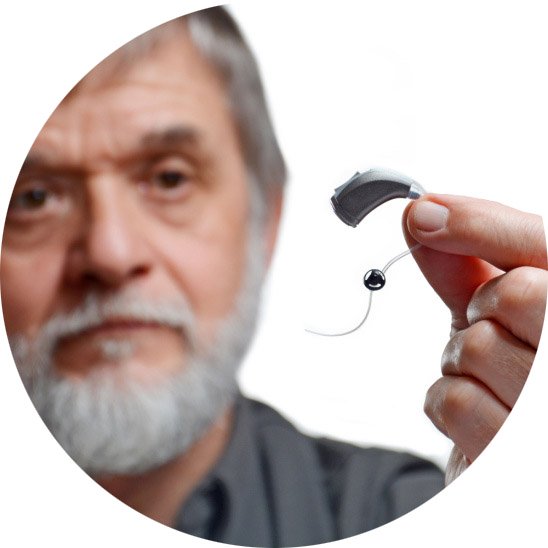 older_male_holding_hearing_aid