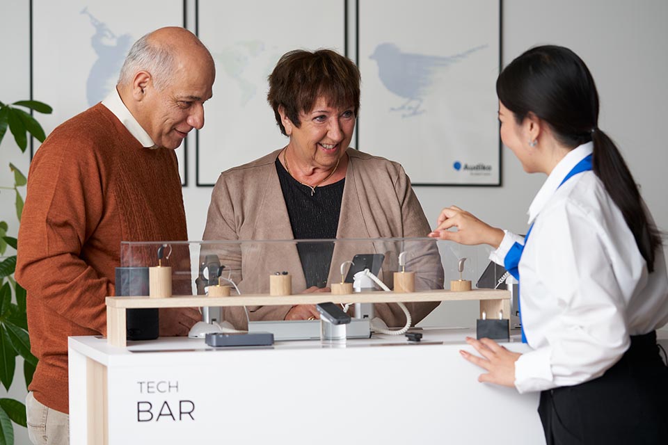 People in Audika clinic discussing different types of hearing aids